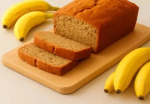Slice of easy banana bread on a plate with a banana and walnuts